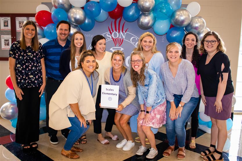A group of teachers smile